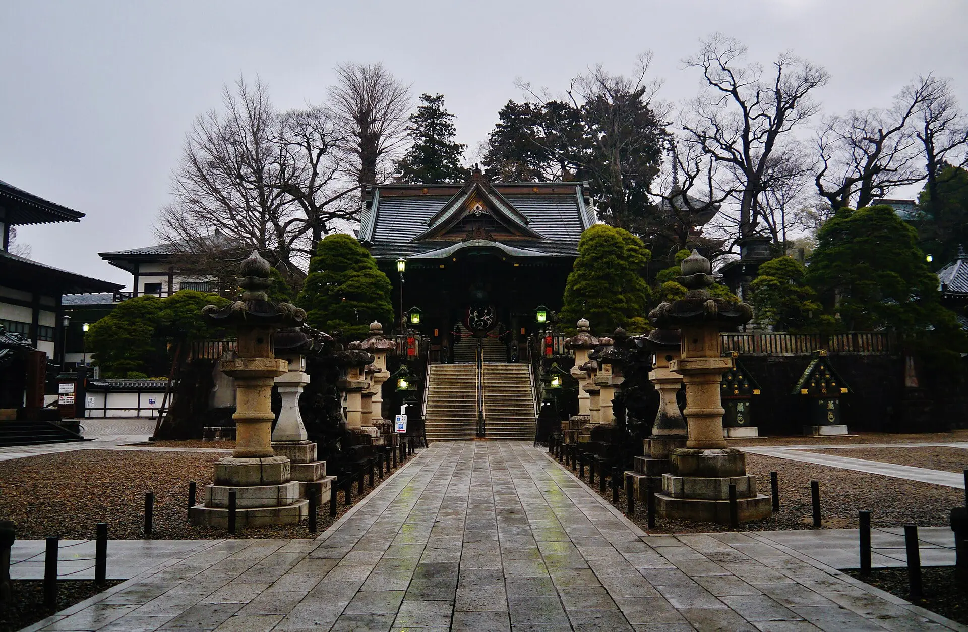 石灯籠が並ぶ参道の奥に建つ成田山新勝寺の仁王門