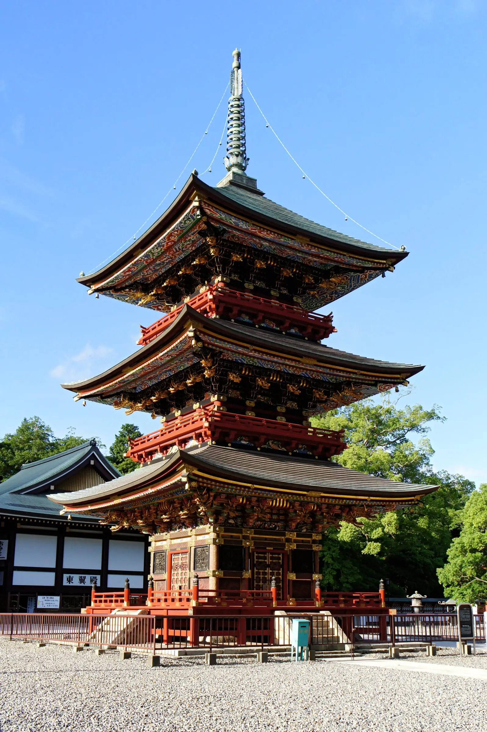 青空を背に斜め下から見上げた三重塔の三層の屋根