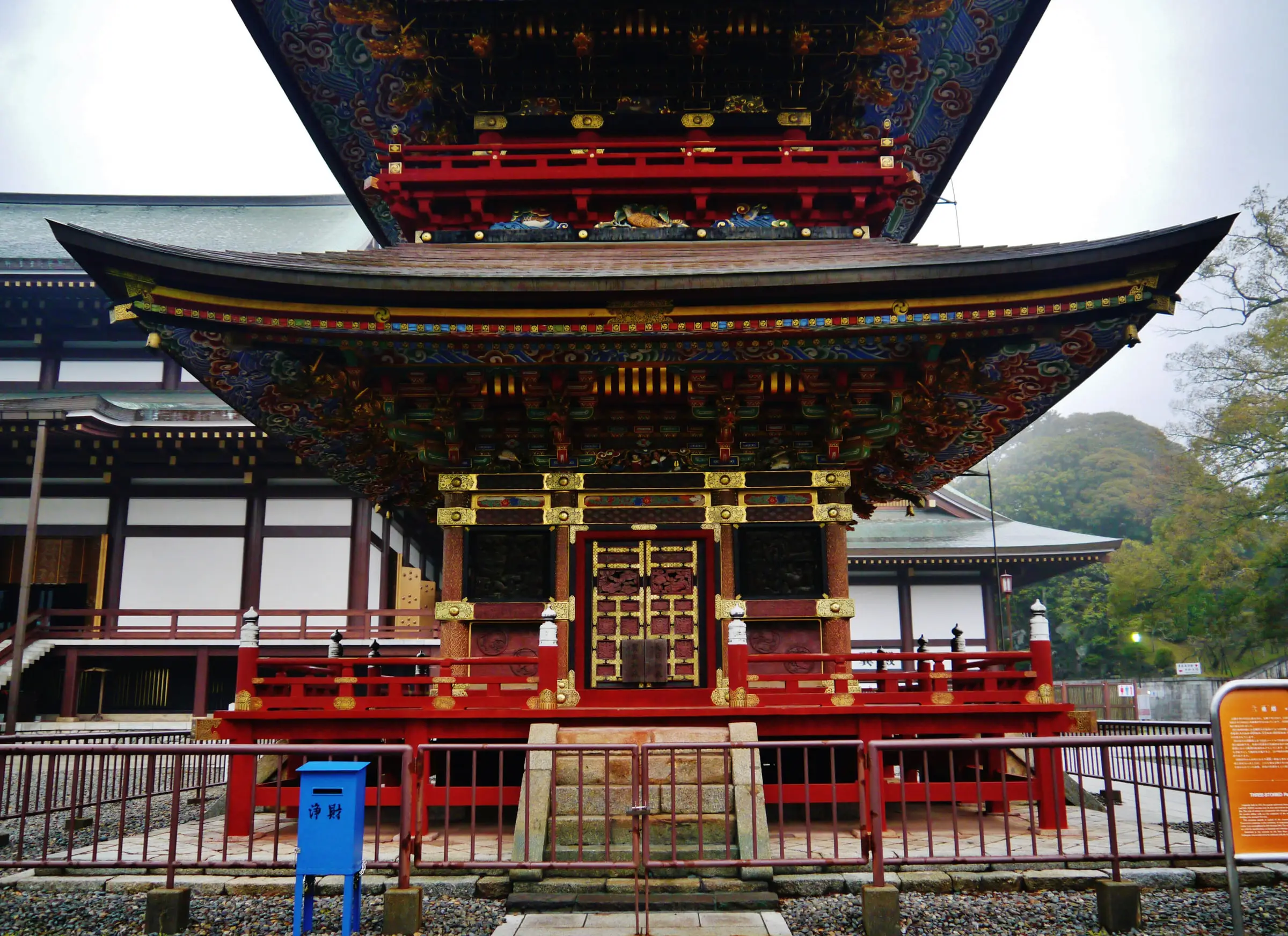 成田山新勝寺 三重塔の初重正面。朱色の高欄の奥に金色の扉と極彩色の組物が見える