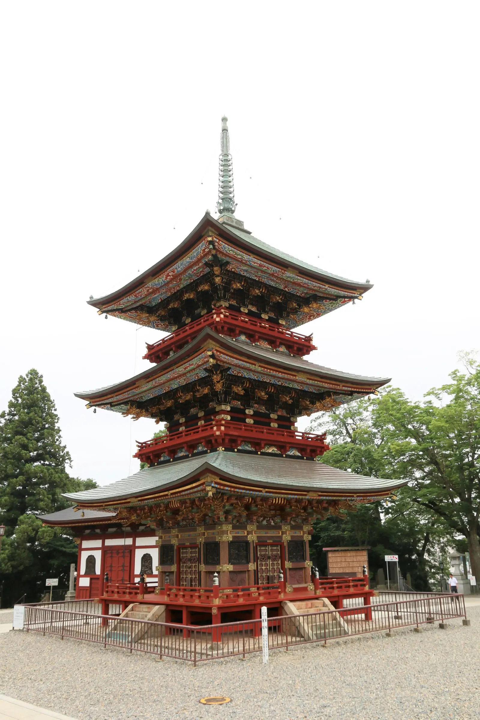 玉砂利の敷かれた上境内に立つ三重塔