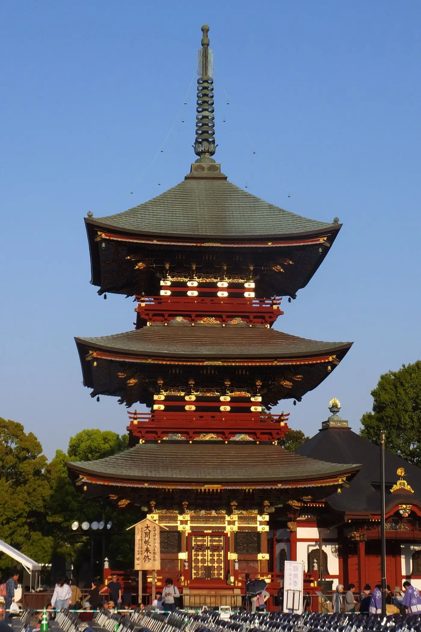 参拝者の頭上にそびえる三重塔